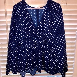Long sleeve navy blouse with white polka dots.